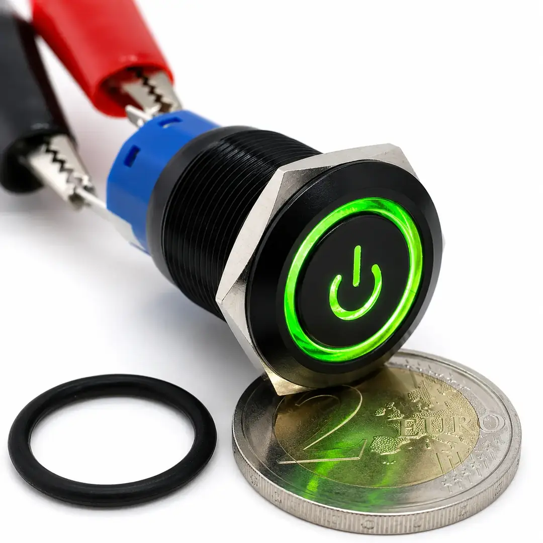 Pulsante monostabile da pannello Ø19 mm con corpo nero, simbolo Power e anello LED verde 12 V, mostrato con guarnizione e moneta da 2 euro.